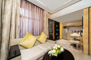 上海静安凯宾斯基全套房酒店的客厅配有白色沙发和黄色枕头。