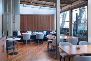 伊斯坦布尔莱文特德德曼酒店的餐厅设有桌椅和窗户。
