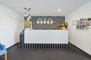 洛坎普顿Quality Resort Parkhurst的大堂设有白色的台面,墙上挂着鲜花