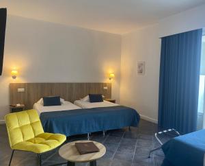 卡尔维卡尔维大酒店的酒店客房,设有两张床和一张黄色椅子