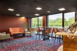维德瑙b-smart hotel Widnau的一间设有椅子和桌子的等候室,窗户