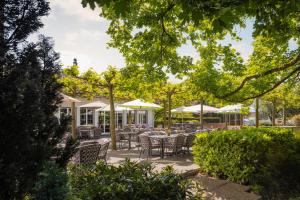 维德瑙b-smart hotel Widnau的一个带桌椅和遮阳伞的庭院