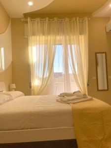 那不勒斯Terrazza Garibaldi的一间卧室设有两张床和窗户。