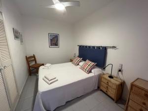 圣地亚哥海滩贝拉维斯塔戈梅拉公寓的卧室配有一张白色大床和一把椅子