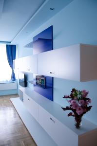 布达佩斯蓝色奢华公寓的厨房配有白色橱柜和花瓶
