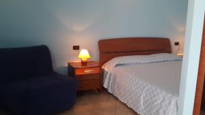 克罗托内Rose Apartment的一间卧室配有一张床、一盏灯和一把椅子