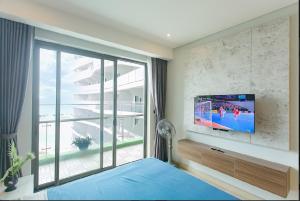 下龙湾Homestay Citadines 2 Ngủ View Biển的卧室设有窗户,墙上配有电视