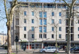 南特B&B HOTEL Nantes Centre的前面有停车位的建筑