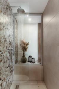 阿菲托斯Verano Afytos Hotel的浴室设有玻璃墙淋浴和花瓶