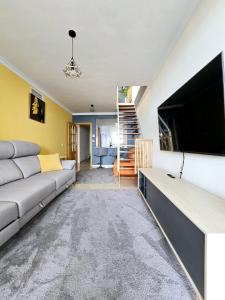 马尼尔瓦Seaview Penthouse Magnificó Ático Duplex con vistas al mar的带沙发和平面电视的客厅