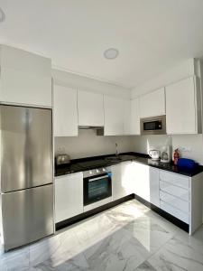 内尔哈SHR043 Nerja Medina Apartamento cerca de Playa Torrecilla的厨房配有白色橱柜和不锈钢用具