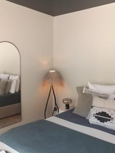 博尼法乔Hôtel Les Suites Du Maquis的一间卧室配有一张带灯和镜子的床