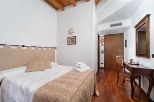 马内尔巴洛坎达达维托里奥酒店的一间卧室配有一张床、一张桌子和一张桌子