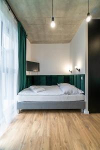 什切青Apartamenty Silver Place的一间卧室配有一张带绿色窗帘的大床