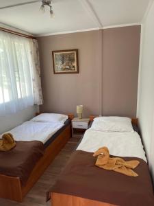 TahitótfaluPanoráma Nyaraló的客房内的两张床和毛巾