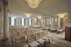 苏黎世Mandarin Oriental Savoy, Zurich的大型客房配有桌椅和吊灯。