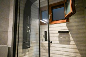 特尔斐Komody的浴室里设有玻璃门淋浴