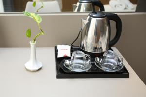 伏罗拉Charm Hotel的茶壶和茶杯放在柜台的托盘上