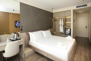 伏罗拉Charm Hotel的卧室配有一张白色大床和一张书桌