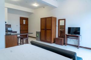 拉维尼亚山Iddamal Apartments的客房设有1张床、1张办公桌和1台电视。