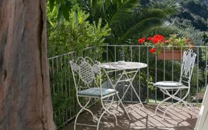 费拉约港圣斯特凡诺酒店 的围栏前的两把椅子和一张桌子