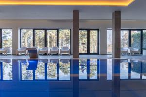 里贝拉迪佩纳Pena Park Hotel的客房设有带椅子和窗户的游泳池。