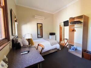 惠灵顿卡明斯宾馆的配有一张床和一张书桌的酒店客房