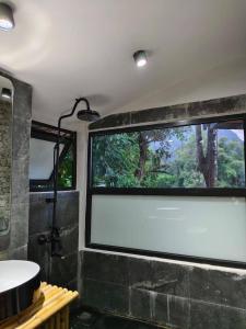 万荣Family Land Camping Resort的带淋浴和盥洗盆的浴室以及窗户。