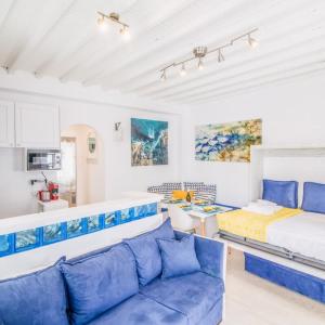 米克诺斯城Like a white seagull in Mykonos!的客厅配有床和蓝色沙发