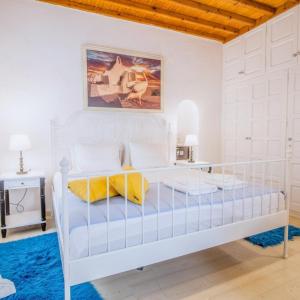 米克诺斯城Like a white seagull in Mykonos!的白色卧室配有白色床和黄色枕头