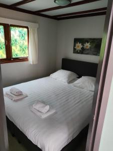 皮滕Vakantiehuisje Veluwe bij Speuldersbos的卧室配有带毛巾的大型白色床