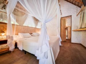 圣阿马鲁Vila do Junco的一间卧室配有一张带蚊帐的床