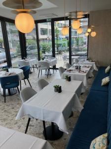 克诺克－海斯特亚特兰大克诺克酒店的餐厅设有白色的桌椅和窗户。