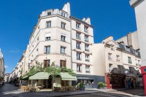 巴黎Hotel Apolonia Paris Mouffetard, Sure Hotel Collection by Best Western的一条城市街道上高大的白色建筑