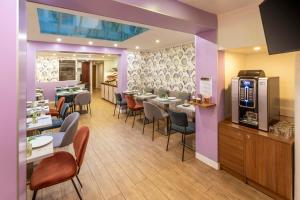 巴黎Hotel Apolonia Paris Mouffetard, Sure Hotel Collection by Best Western的餐厅设有桌椅和紫色墙壁