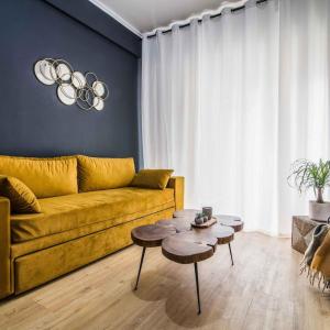 雅典Classy Apartment in Athens的客厅配有黄色的沙发和桌子