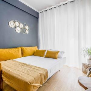 雅典Classy Apartment in Athens的一间卧室配有一张带黄色枕头的大床
