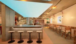 尼斯Greet Hotel Nice Aéroport Promenade des Anglais的自助餐厅,设有酒吧,配有凳子和桌子