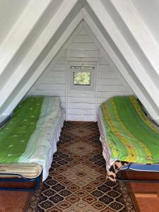 戈尼翁兹SZAŁASY drewniane nad rzeką BIEBRZA的帐篷内带两张床的房间