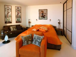 尤尔马拉Boutique Hotel Light House Jurmala的一间卧室配有橙色的床和沙发