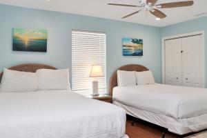 Cape San BlasAbsolute Heaven by Pristine Properties Vacation Rentals的卧室设有两张床铺、蓝色的墙壁和吊扇