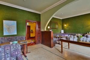 霍巴特阿斯特私人酒店的一间设有绿色墙壁和桌椅的房间
