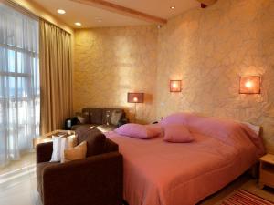 尤尔马拉Boutique Hotel Light House Jurmala的一间卧室配有带枕头的床铺和沙发