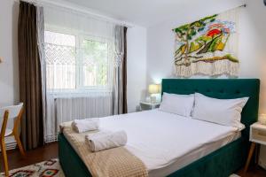 比斯特里察Apartament Corina cu parcare的一间卧室配有一张带绿色床头板的床和窗户