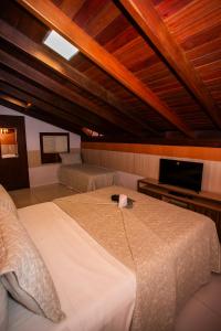 费尔南多 - 迪诺罗尼亚Casa Conceição的一间带大床和电视的卧室