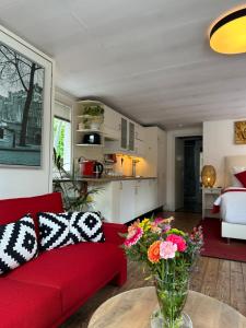阿姆斯特丹Boat no Breakfast的客厅配有红色的沙发和花瓶