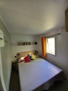 PreciCamping Villaggio Il Collaccio的小卧室配有带色彩缤纷枕头的床