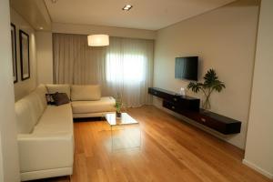 布宜诺斯艾利斯苏普拉大都会酒店的客厅配有白色沙发和电视