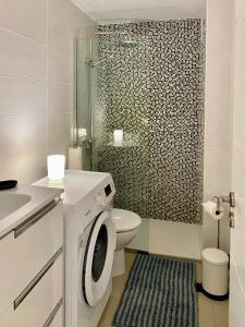 英格兰海滩Tanife 310 - Playa del Ingles comfort Suite with Sunset view的浴室配有卫生间、淋浴和洗衣机。