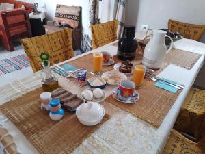 米多恩Djerba rêve vacances Zohra的一张桌子,上面有早餐食品和橙汁